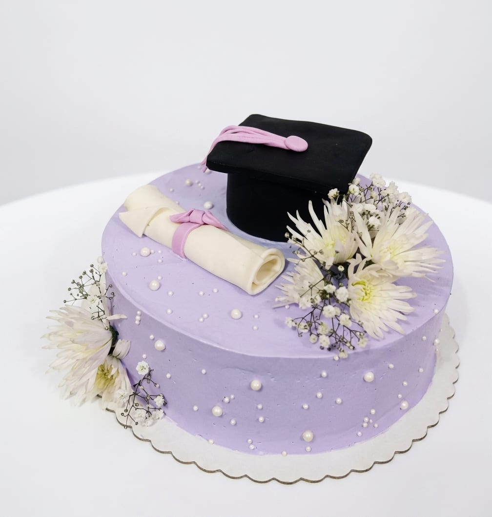 Torta de graduación lila con birrete, diploma de fondant y flores naturales