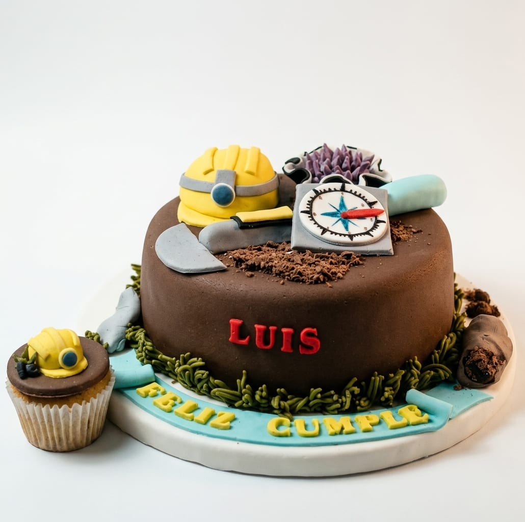Torta temática de ingeniería con casco, brújula y herramientas modeladas en fondant